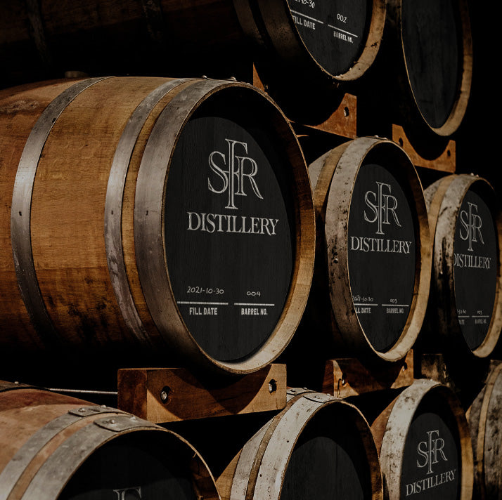 Wooden barrels with SFR Distillery labels stacked together