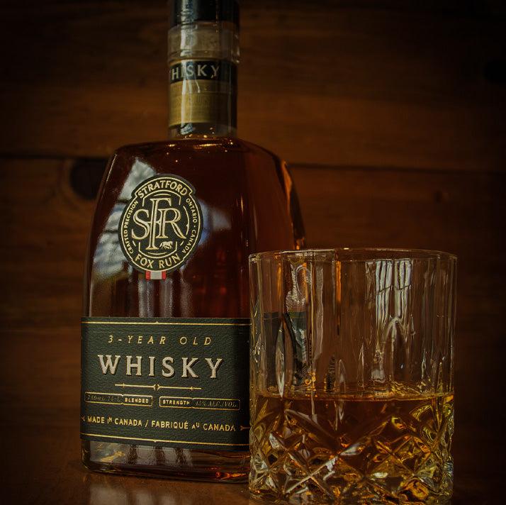 SFR Distillery bottle of 3-year-old whisky with a glass on a wooden surface.